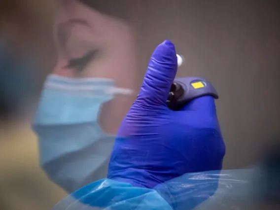 Rebekah Dowling processes COVID-19 test samples under a hood in a microbiology lab, Oct 4, 2021, at TGen North in Flagstaff, Arizona.