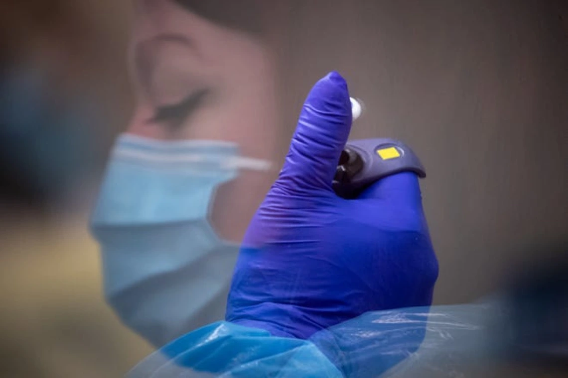 Rebekah Dowling processes COVID-19 test samples under a hood in a microbiology lab, Oct 4, 2021, at TGen North in Flagstaff, Arizona.